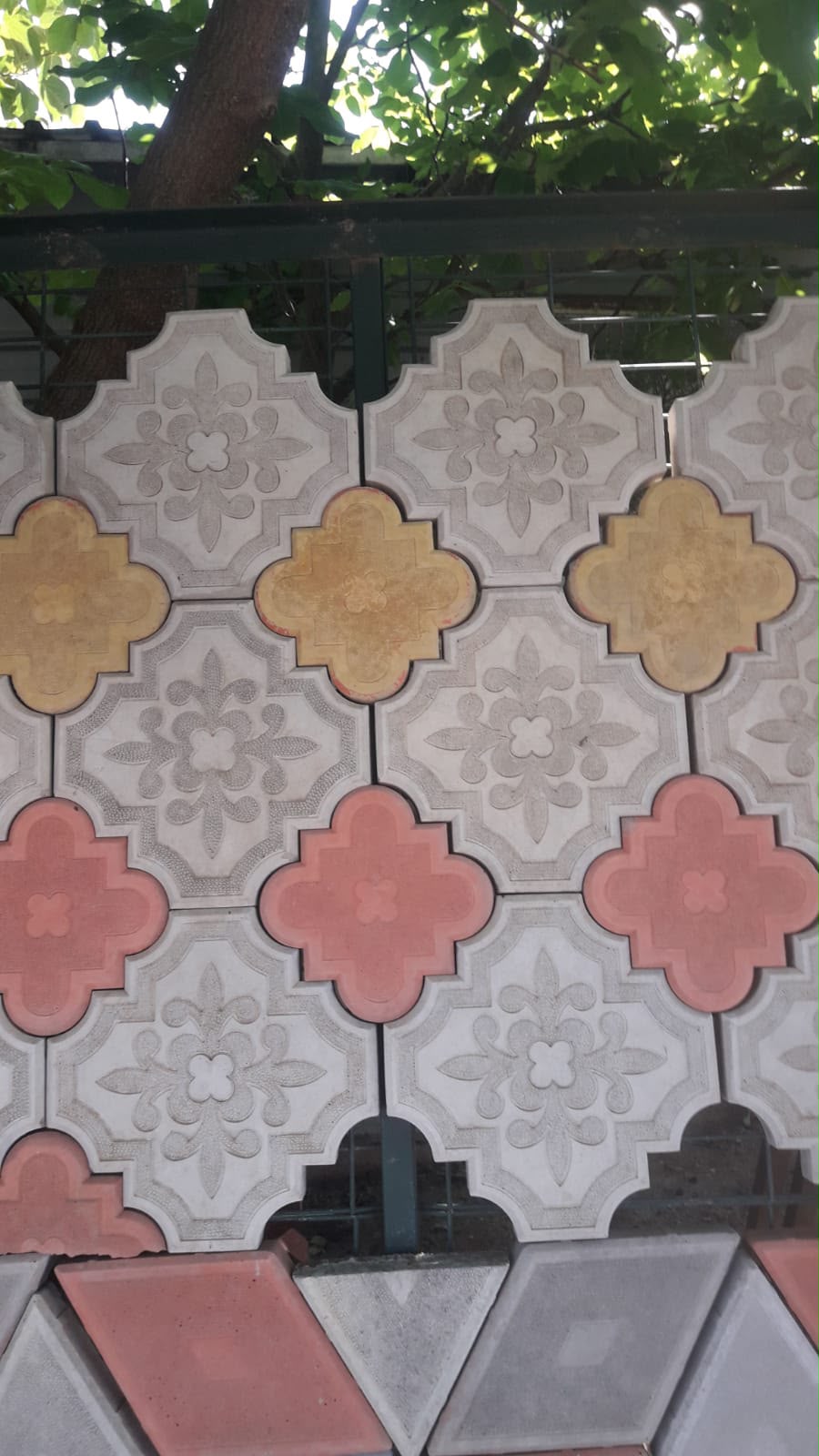 Showroom vitrininde gri kırmızı sarı renkli dekoratif desenli kilit parke taş modelleri