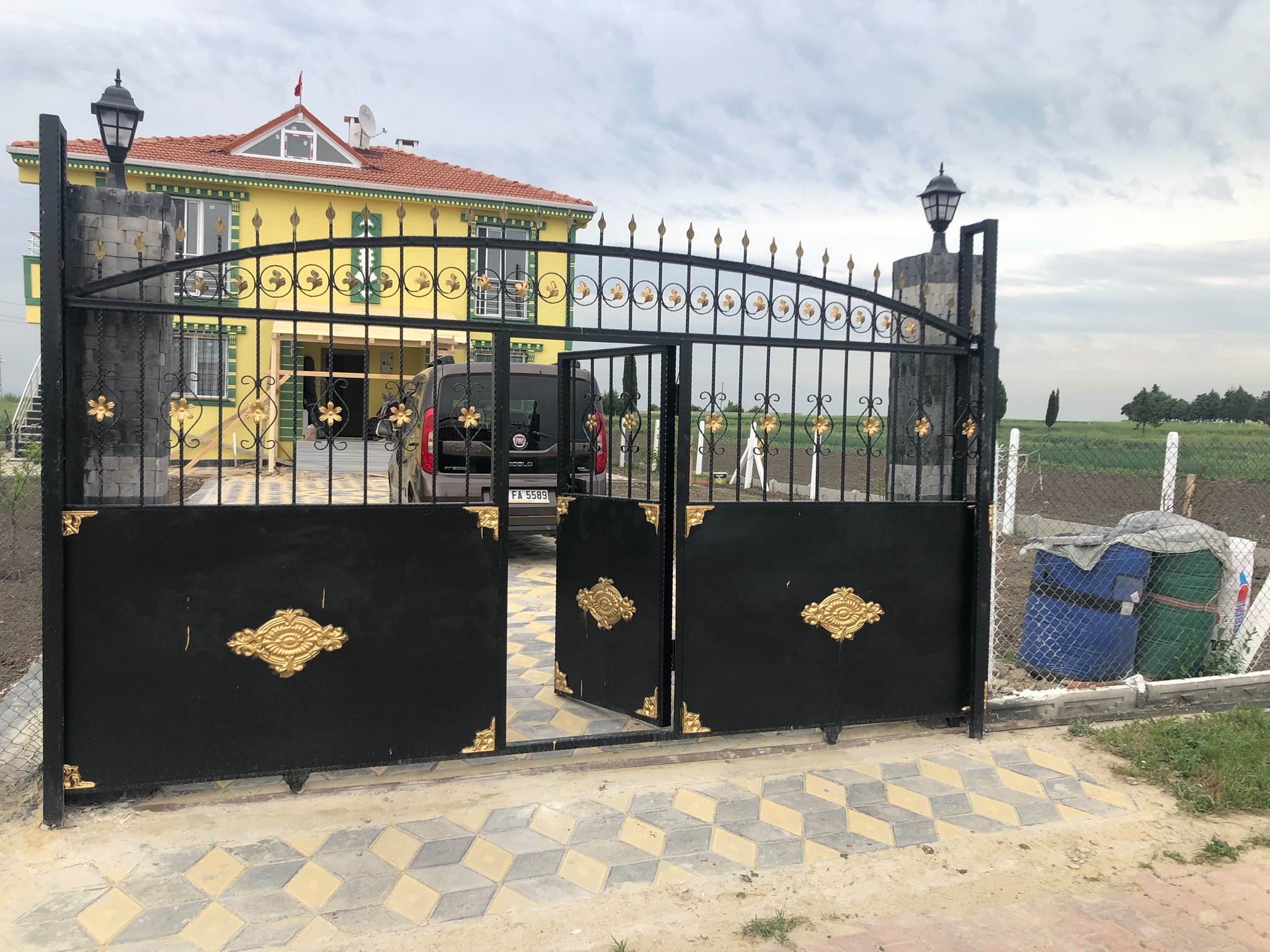 Taş sütunlu altın motifli ferforje bahçe kapısı ve 3d kilit taşlı villa girişi