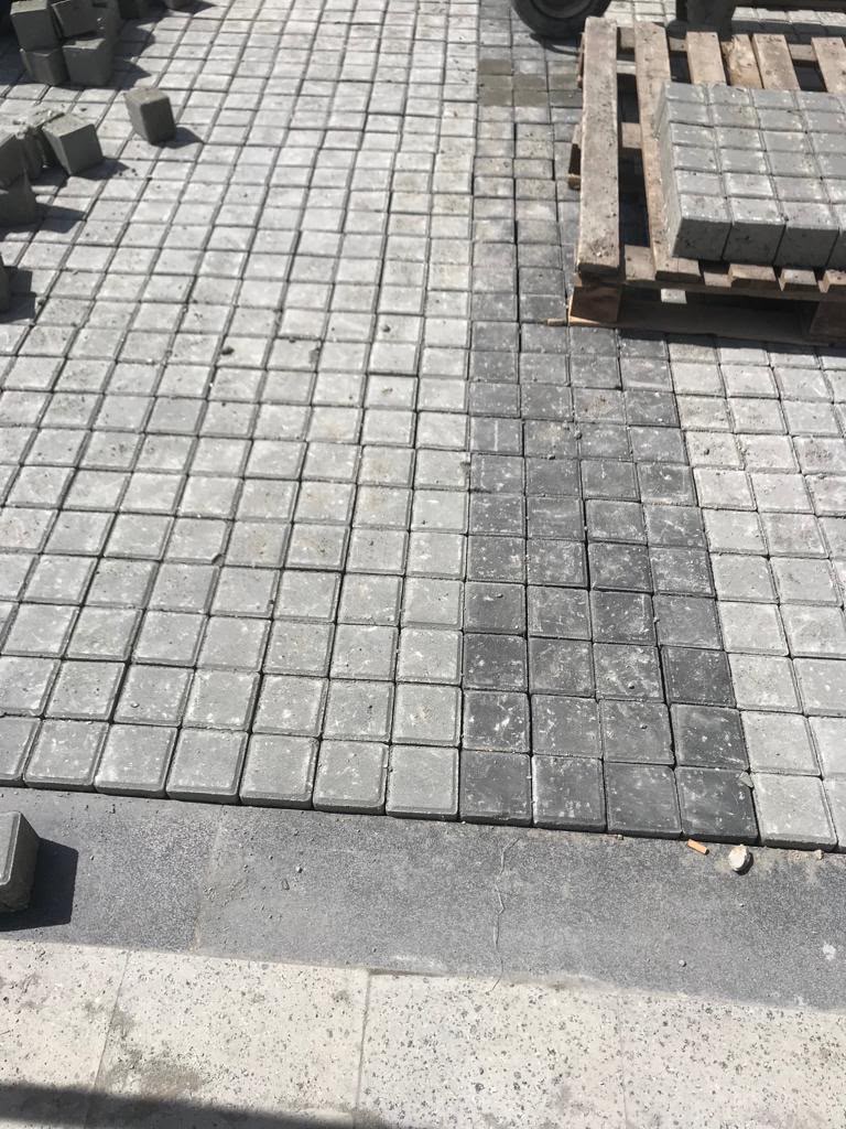 Gri ve antrasit renkli kare karo taşlarla yapılan bahçe zemin kaplama çalışması