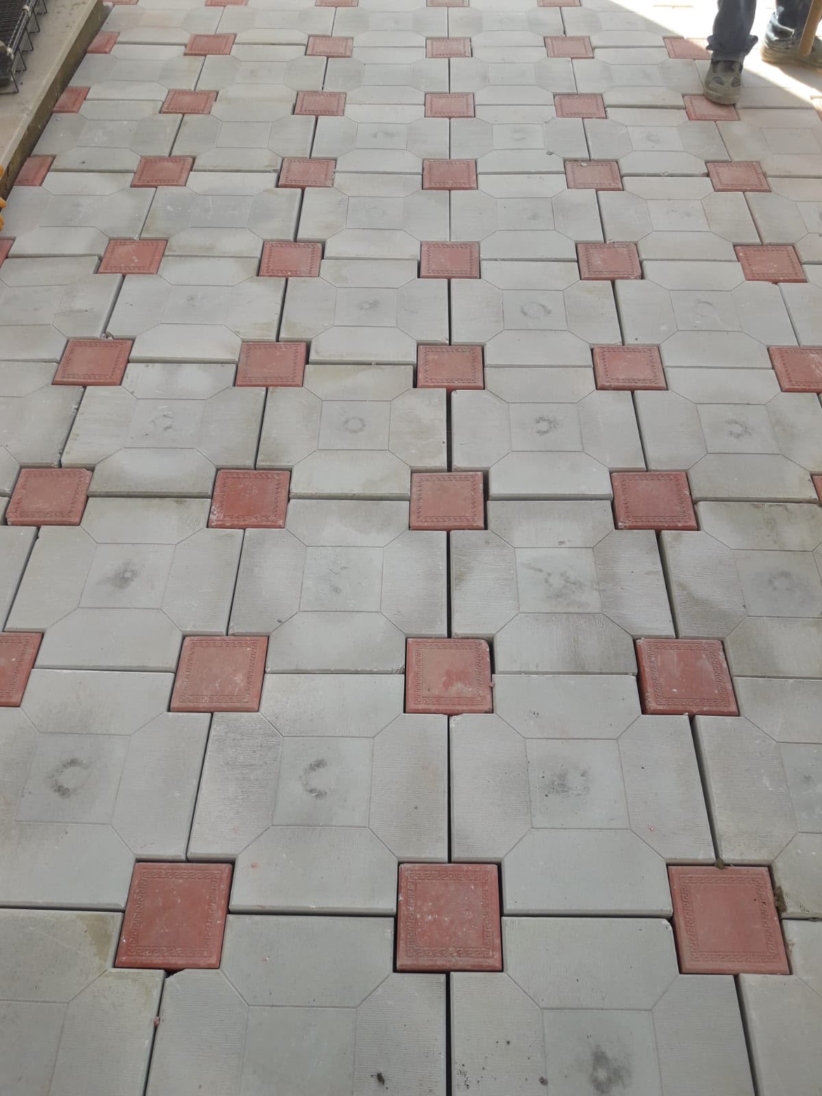 Gri ve kırmızı geometrik desenli kilit parke taşı yakın çekim döşeme görünümü