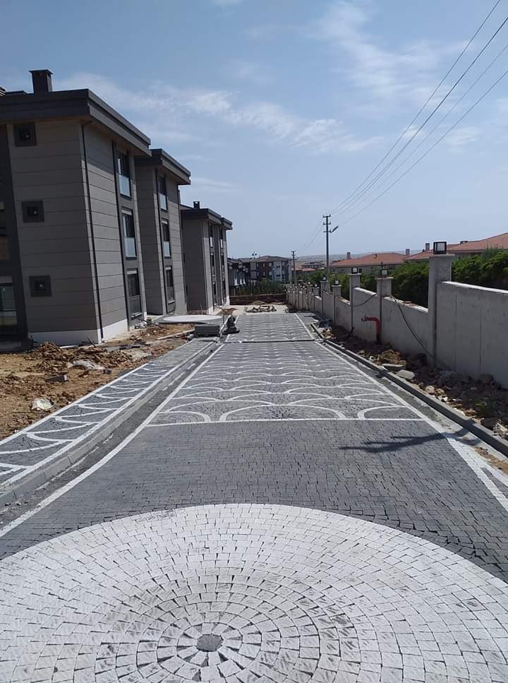 Site içi yolda granit küp taş yelpaze ve daire desenli profesyonel zemin kaplama
