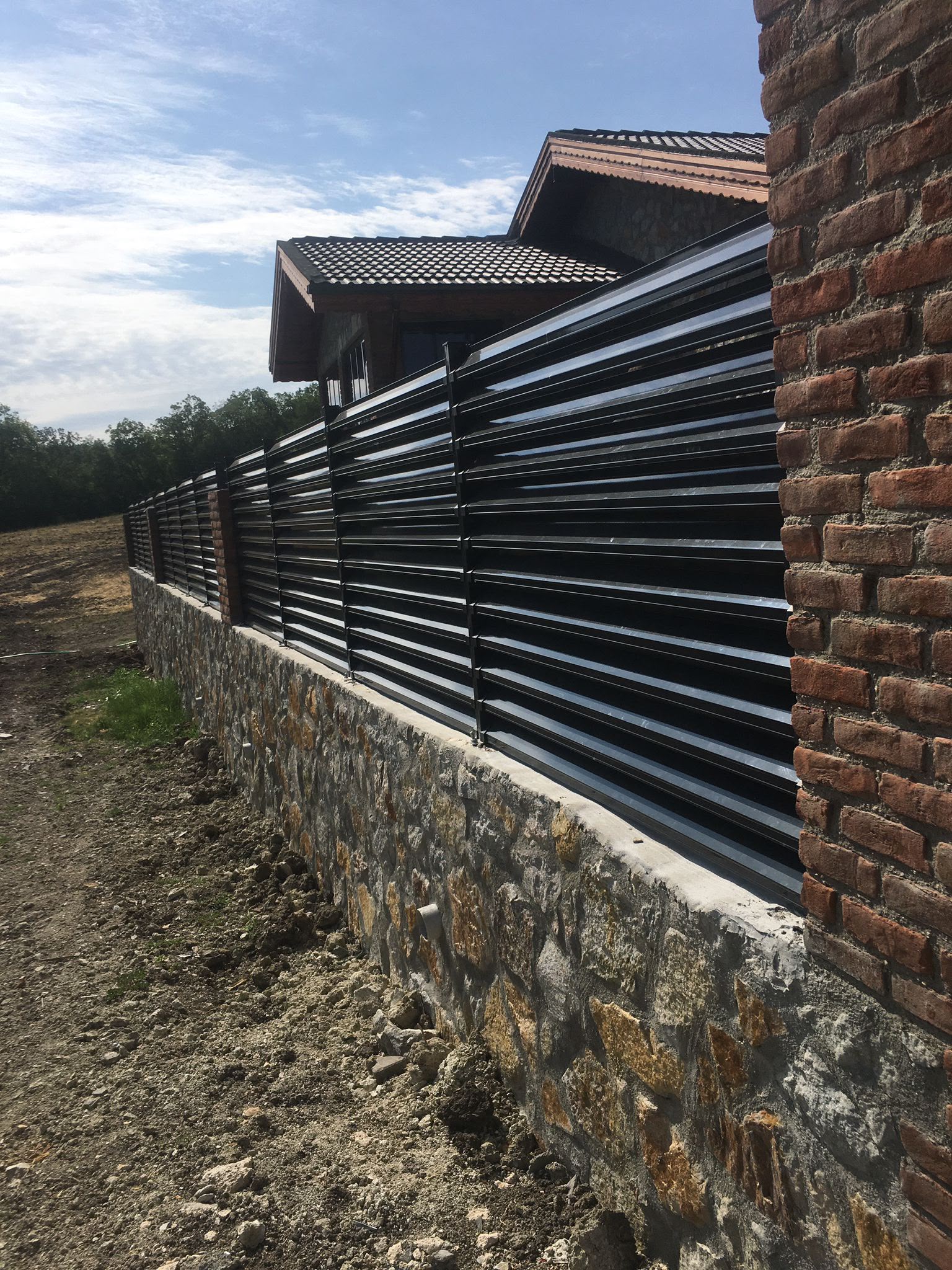 Yatay çıtalı metal bahçe çiti ve taş istinat duvarı uygulaması