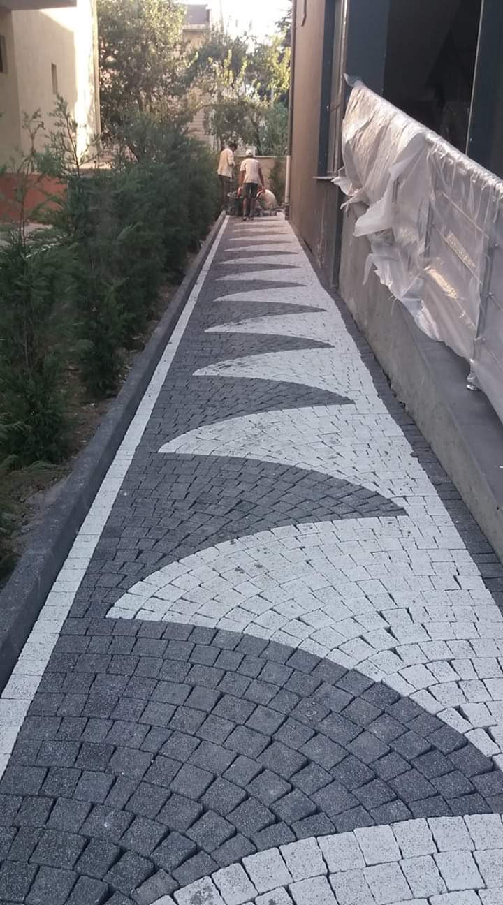 Bahçe yürüyüş yolunda siyah beyaz yelpaze desenli granit küp taş döşeme uygulaması