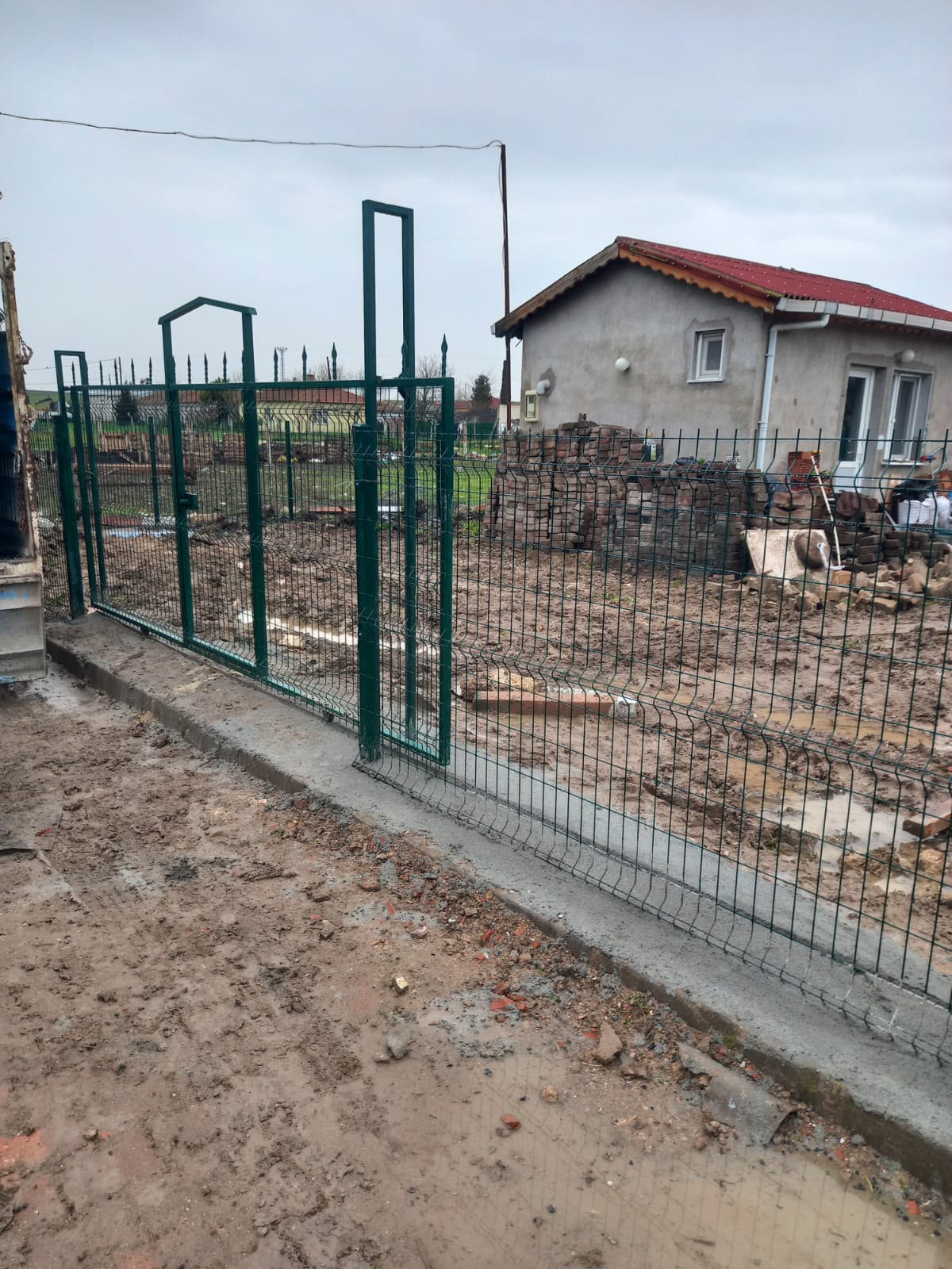 Yeşil panel çit ve kemerli bahçe kapısı