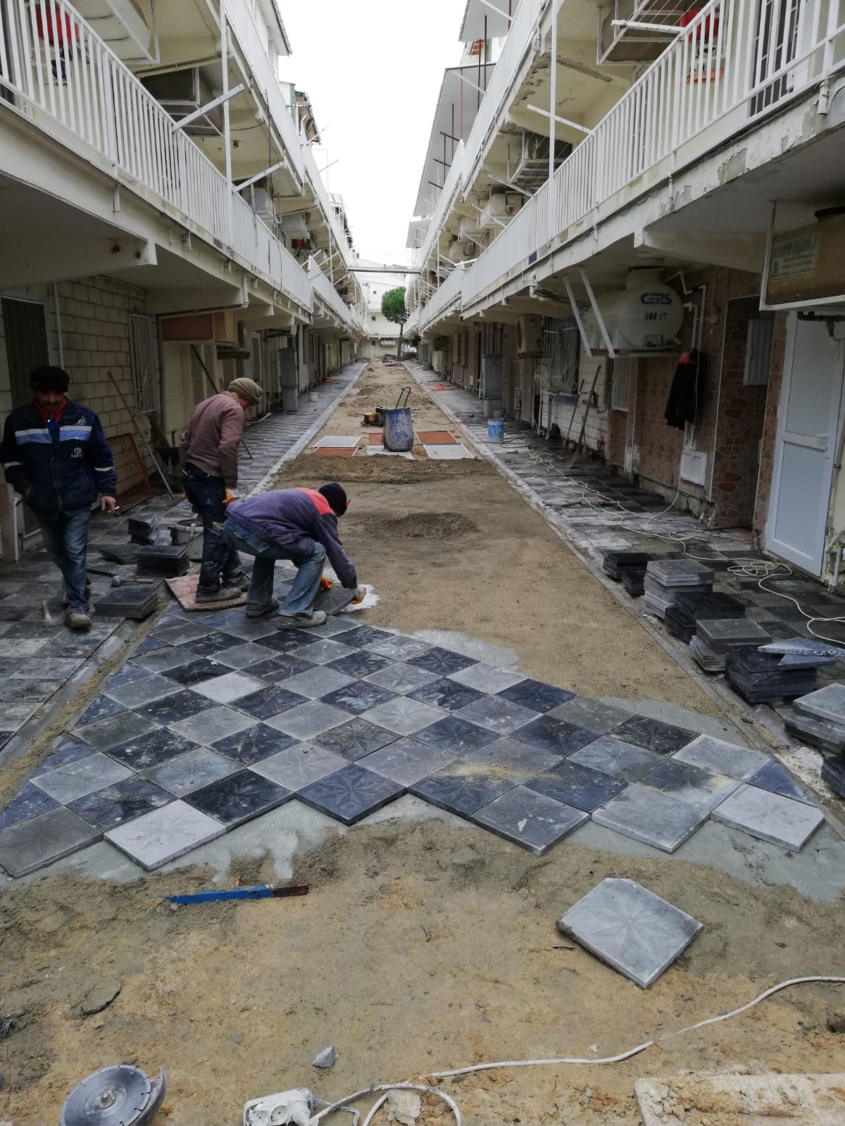 Karakaş Ticaret site içi yıldız desenli gri siyah karo taş döşeme çalışması, usta ekibi
