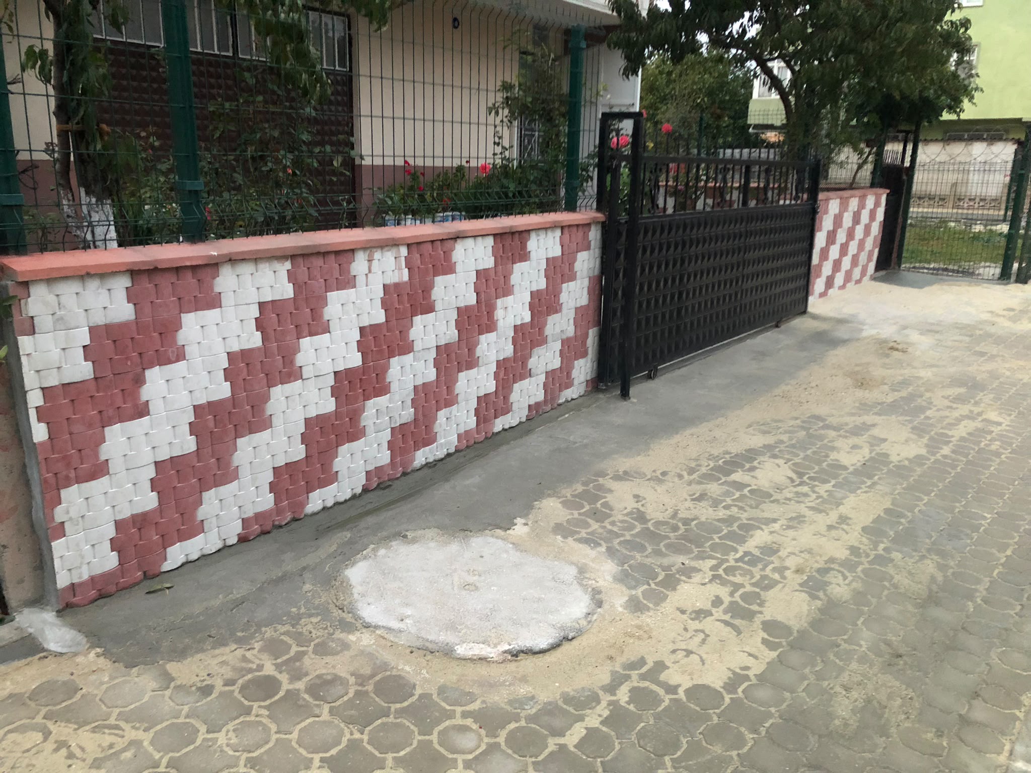 Karakaş Ticaret zigzag desenli karo taş bahçe duvarı, yeşil panel çit ve siyah kayar kapı